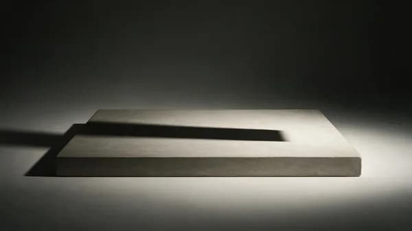 Reference plate: an empty concrete shelf with one hard side light and a long cast shadow