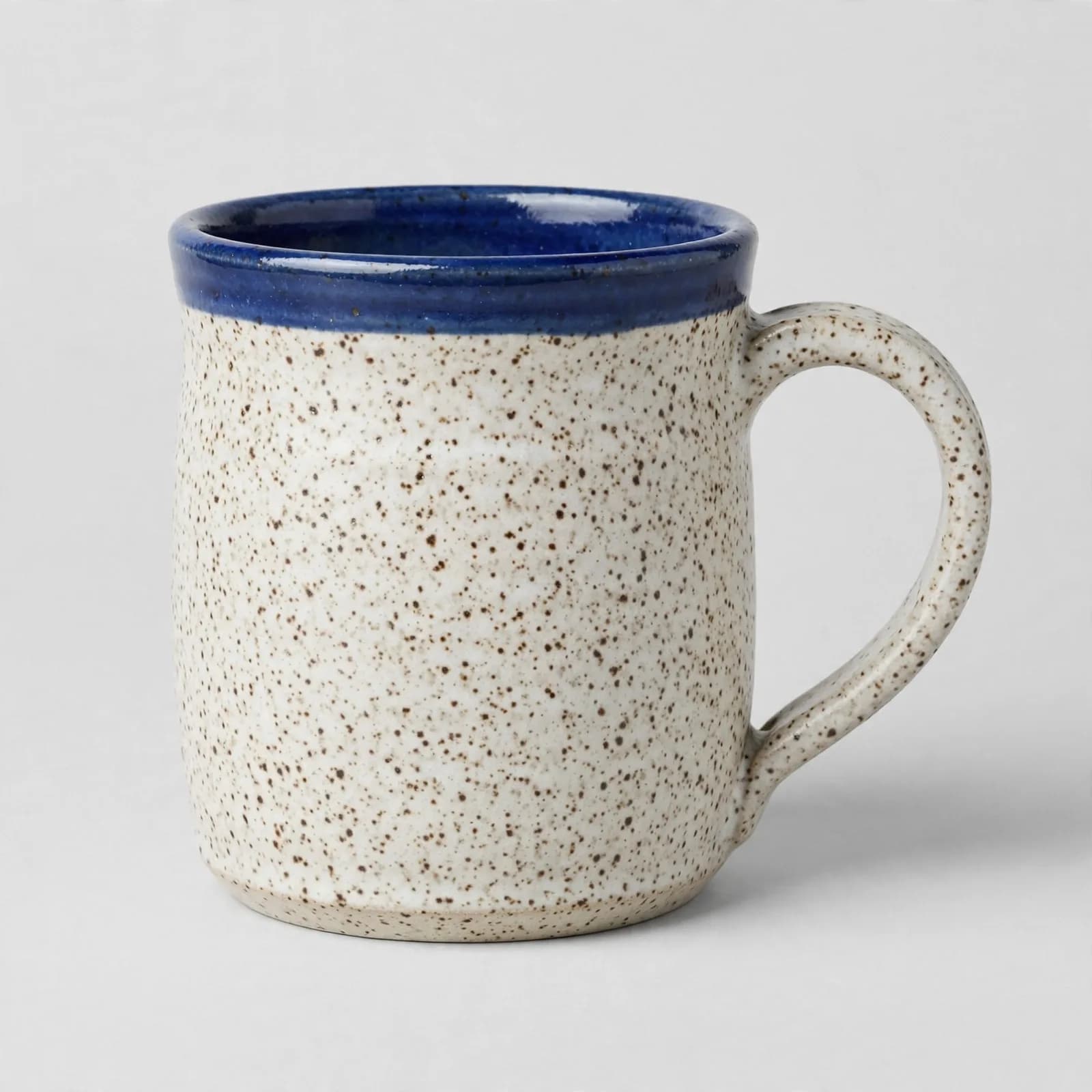 Reference 2: a speckled oat-white ceramic mug with a cobalt-blue rim